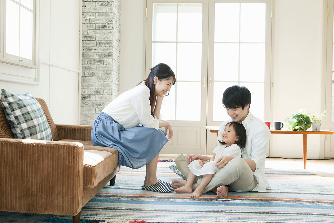 リビングで談笑する家族の写真